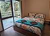 Main bedroom with comfortable queen bed and views of the surrounding bush life. 